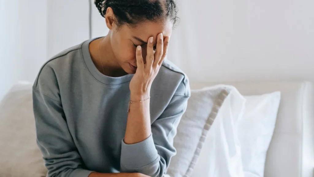 Anxious woman on her bed, showing the mind and body link in chronic pain