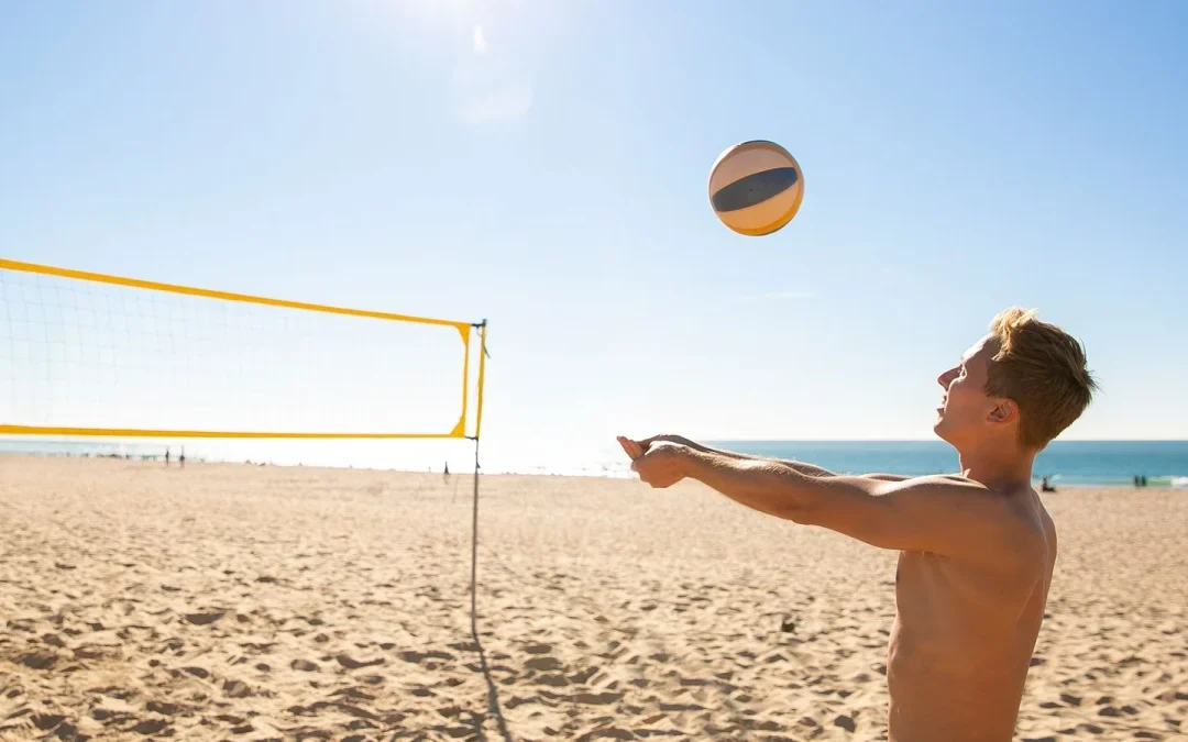 Man playing beach volleyball, enjoying summer activities without back pain