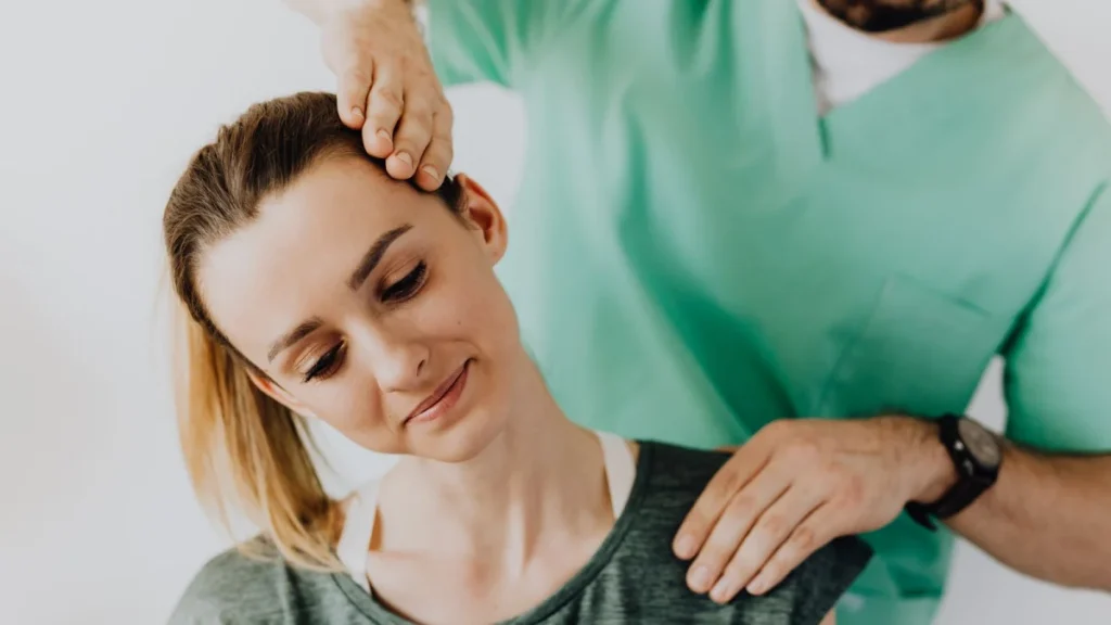 Practitioner gently treating a woman's neck as part of whiplash care