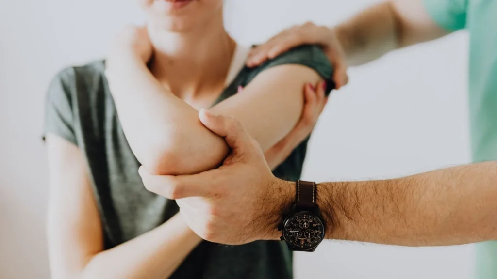 Chiropractor examining the arm joint of a patient, a basic part of the job