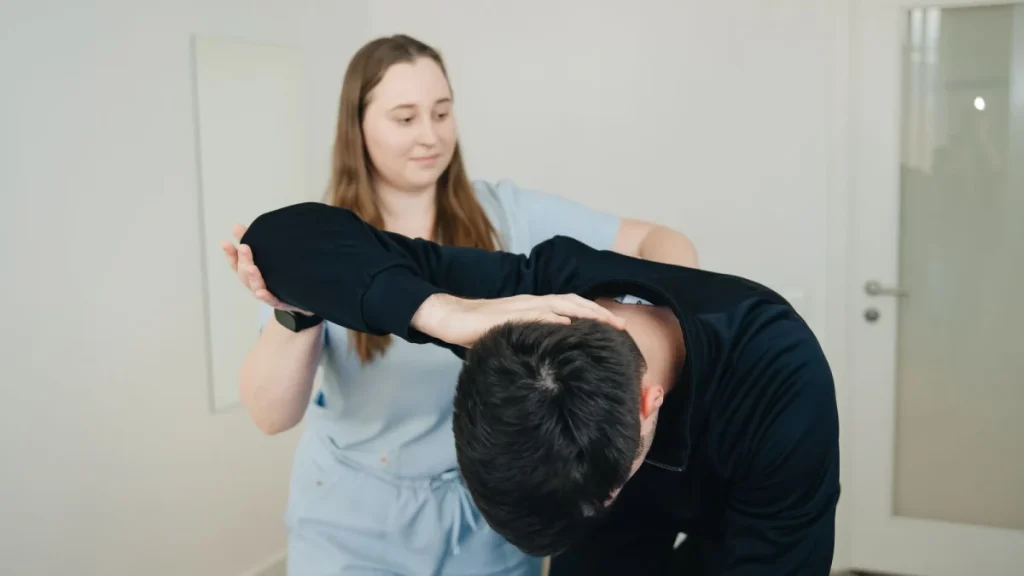 Practitioner helping a man with his back, showing what a chiropractor does