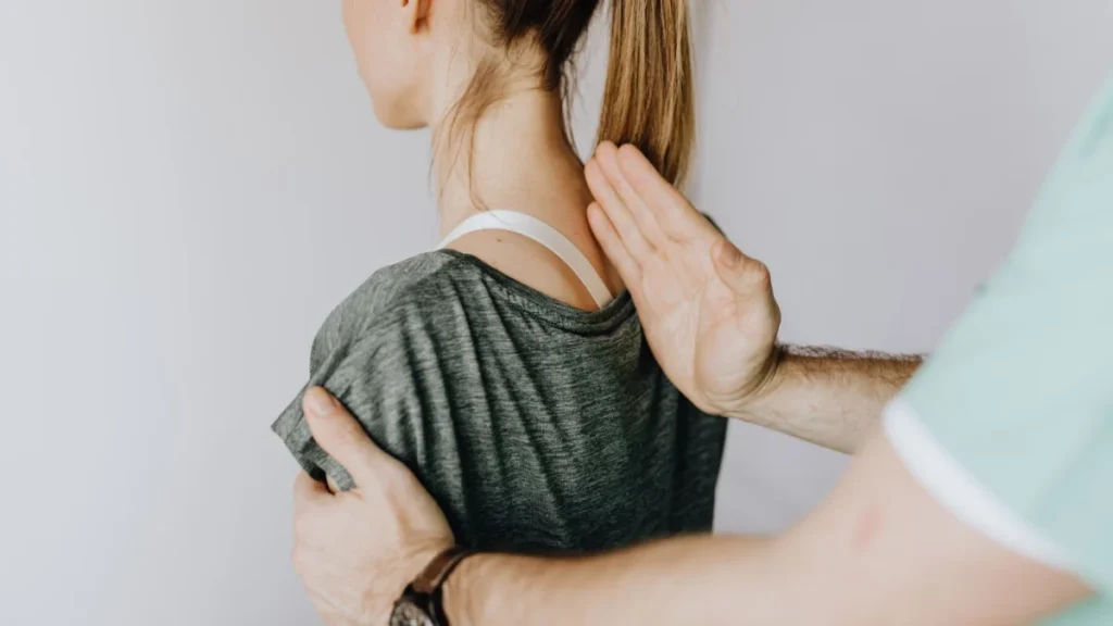 Chiropractor examining a woman's spine to find the source of lower back pain