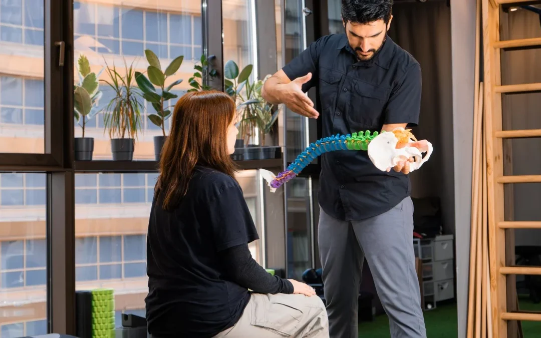 Chiropractor explaining a spine model to a patient during a chiropractic consultation