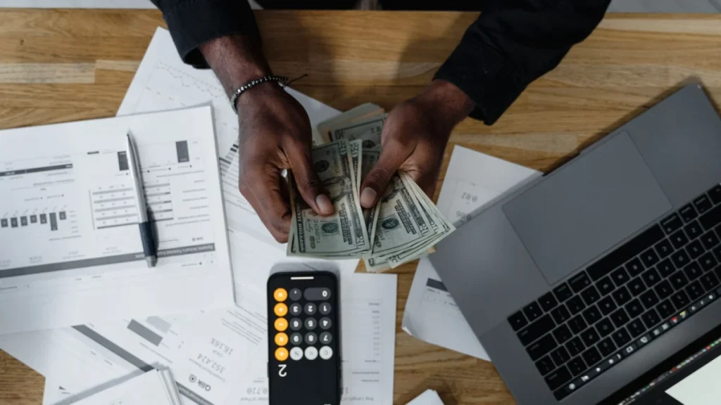 Person counting dollar bills, representing the average salary of a chiropractor