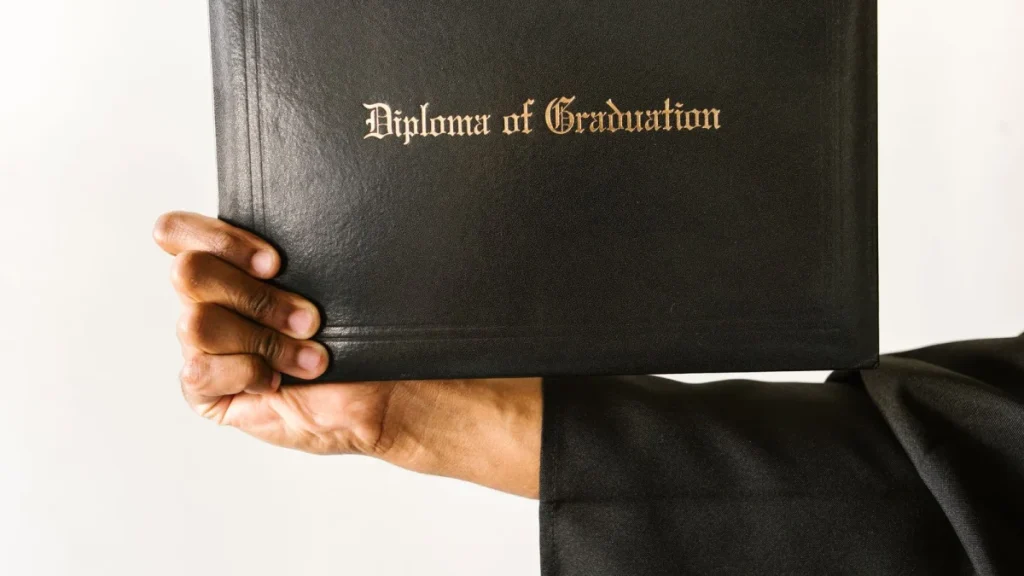 Graduate holding a diploma, reflecting the licensing chiropractors need to practice