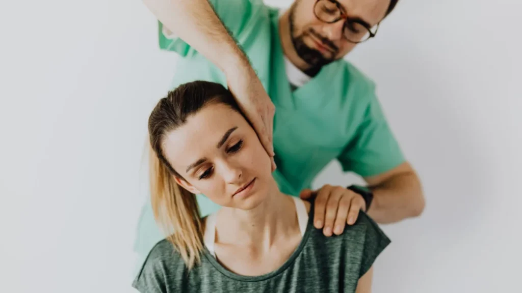 Practitioner treating a woman's injured neck soon after a car accident