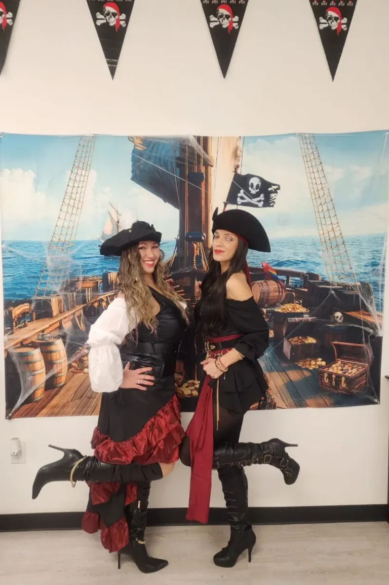 Two Spine and Injury Associates Haines City team members posing in front of a pirate ship backdrop