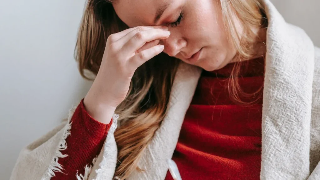 Woman touching her head in pain, a possible sign of concussion after a crash