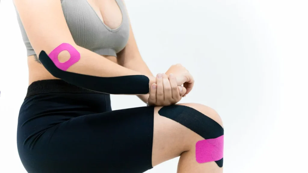 Woman applying kinesio tape to support a soft tissue injury