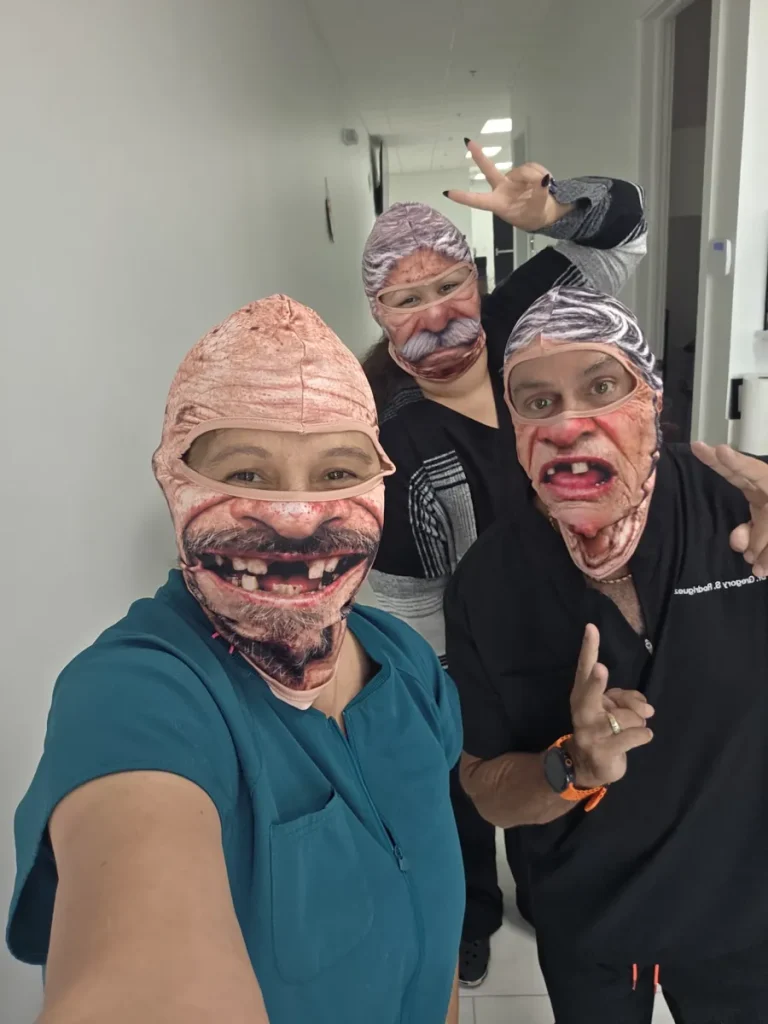 Spine and Injury Associates Kissimmee team in funny old man masks for Halloween 2026