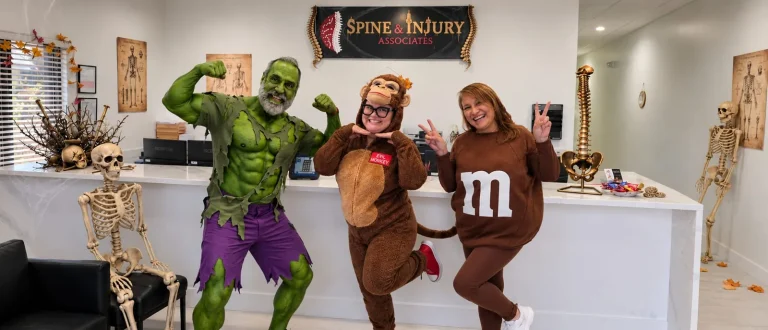 Themed Halloween 2026 photo of the Spine and Injury Associates Kissimmee team posing in costumes
