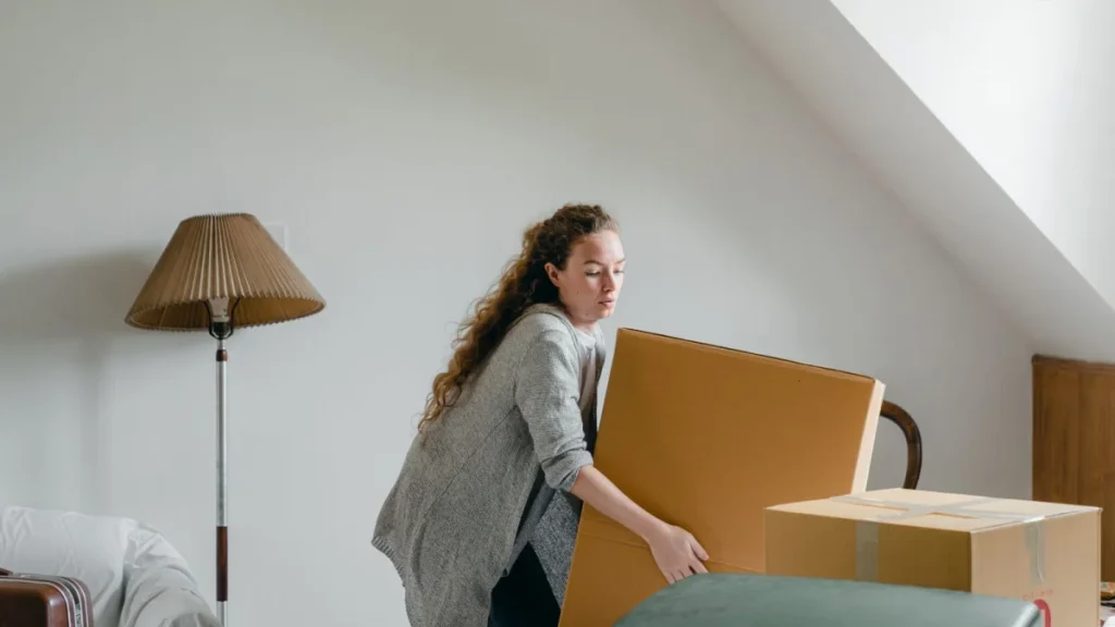 Woman lifting a heavy cardboard box, a common cause of herniated discs