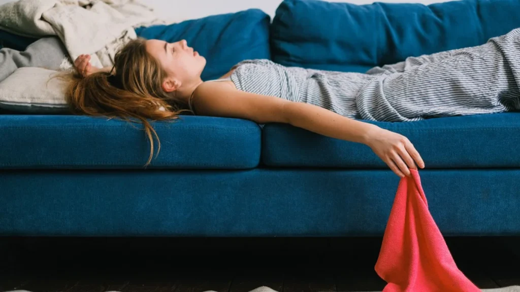 Tired woman resting on her sofa while living with fibromyalgia