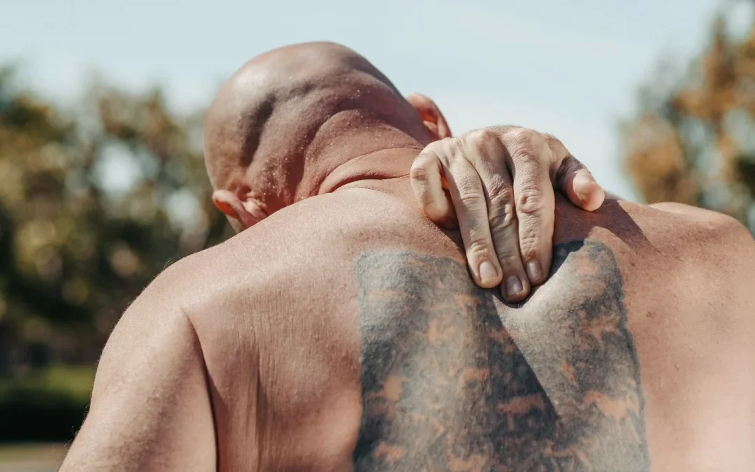 Man holding his back in discomfort while dealing with chronic back pain