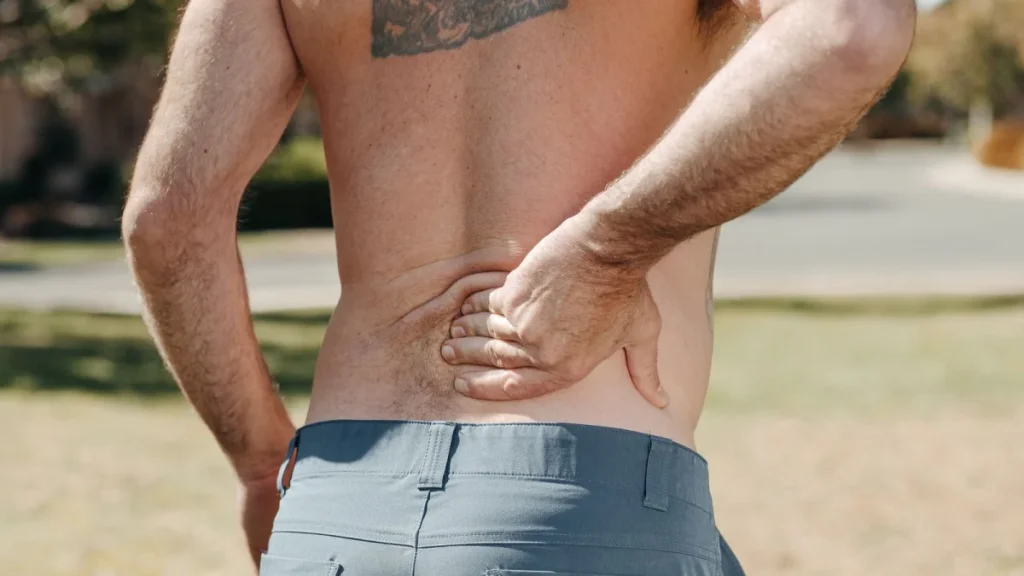 Man holding his lower back, a daily reality for people with chronic back pain