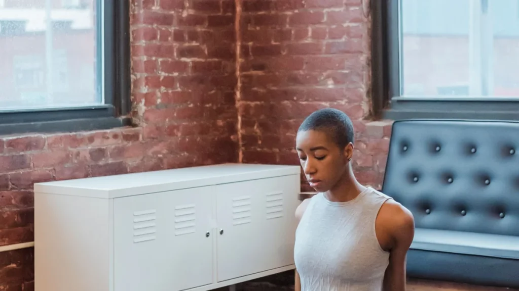 Woman meditating on a yoga mat, a holistic approach to back pain