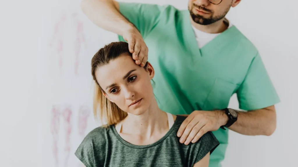 Practitioner examining a woman's neck for whiplash after a car accident