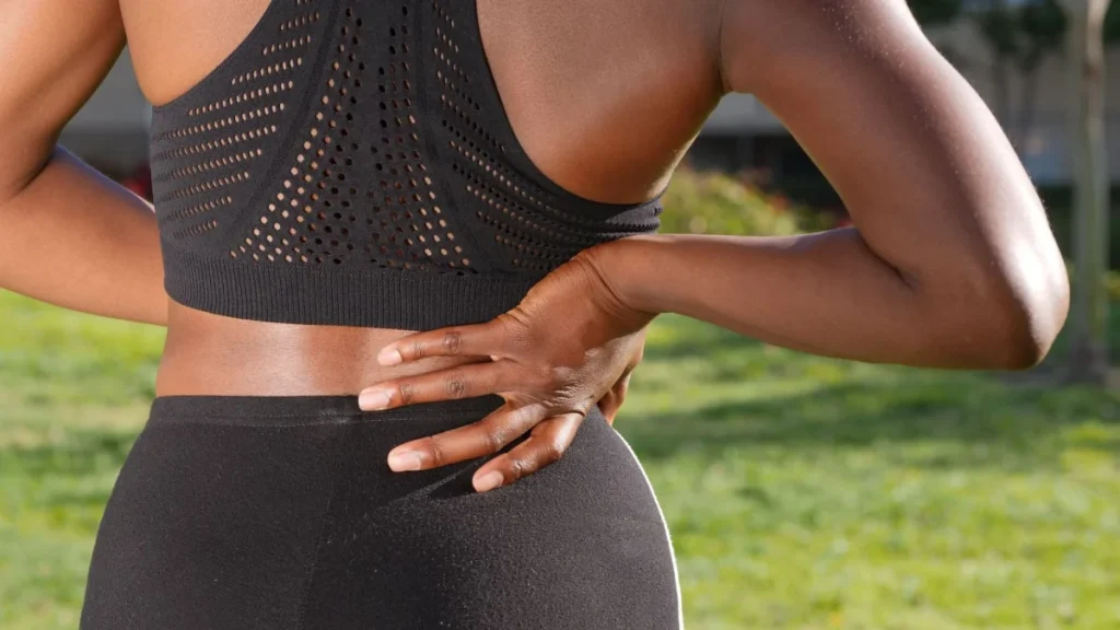 Person holding an aching back, showing typical low back pain symptoms