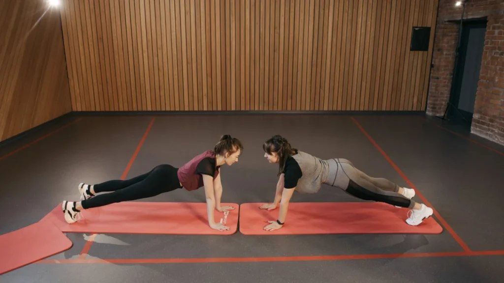 Two women holding planks to strengthen the core and prevent sciatica from returning