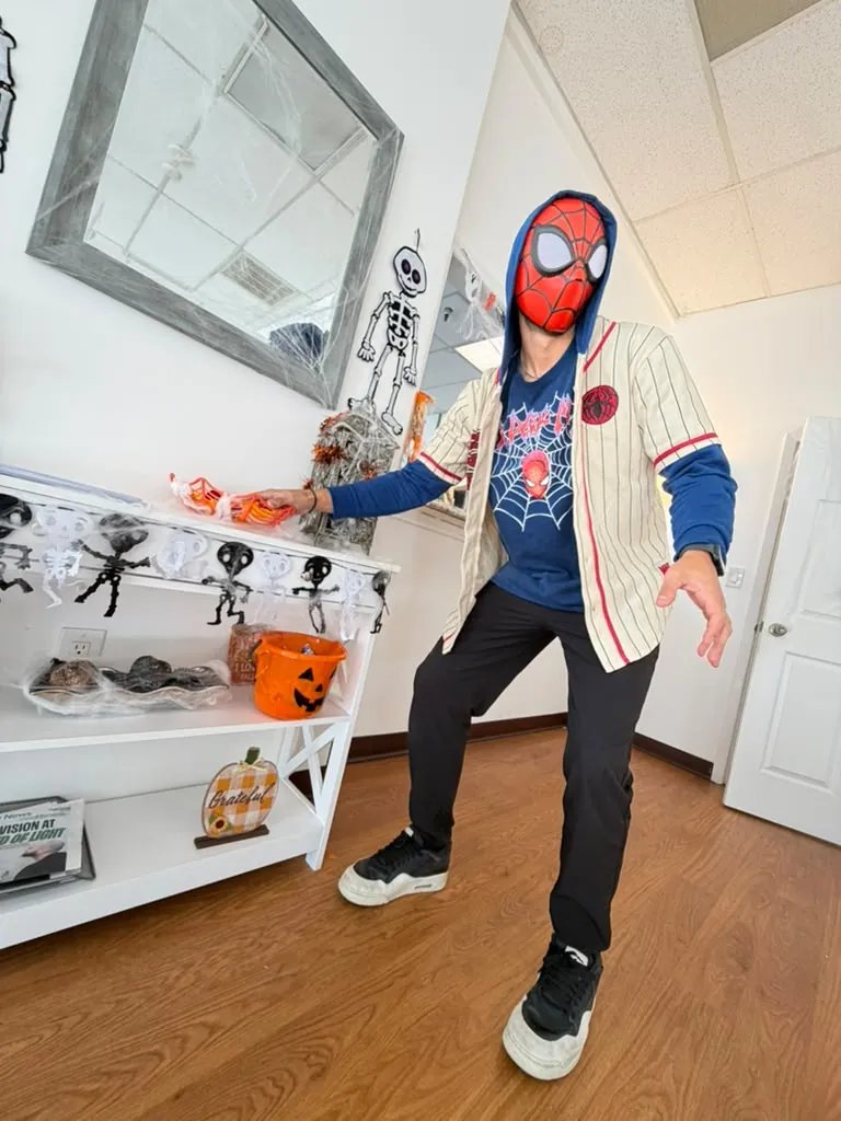 Spine and Injury Associates Plant City team member in costume beside the Halloween decorations in the office