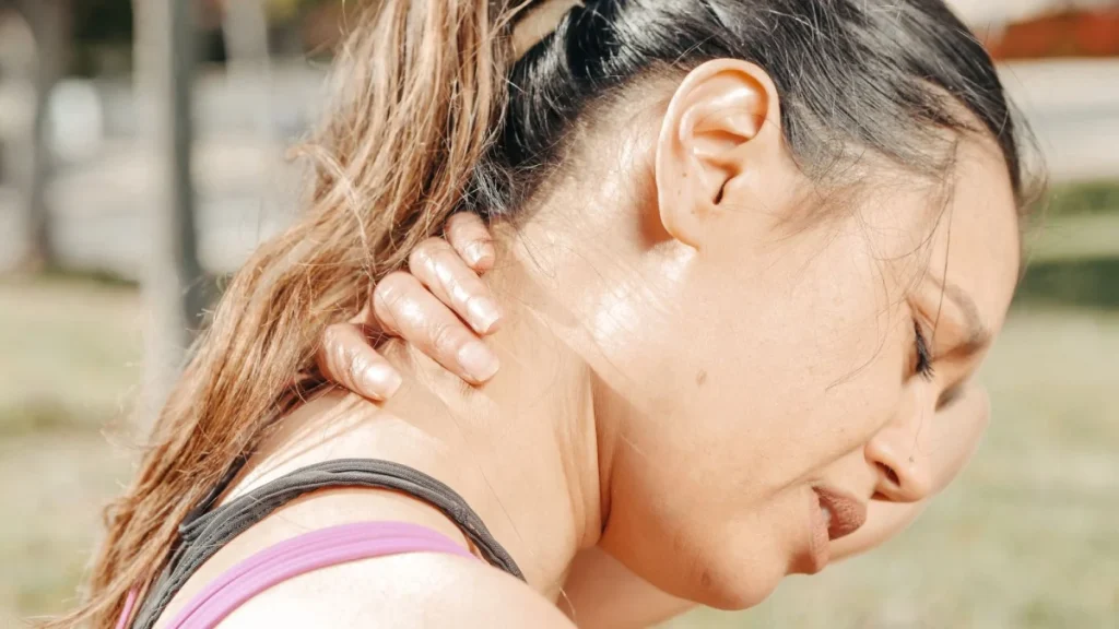 Woman holding her sore neck, one of the main whiplash symptoms