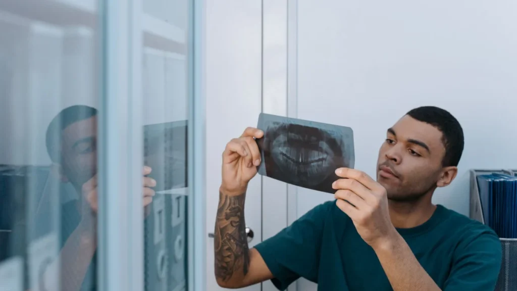 Man reviewing a spinal x-ray image while diagnosing a herniated disc