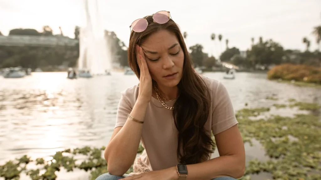 Stressed woman by a lake, as stress may play a role in fibromyalgia