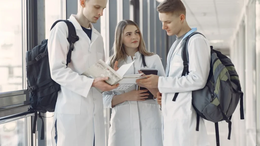 Students sharing notes in a university hallway on the educational path to chiropractic