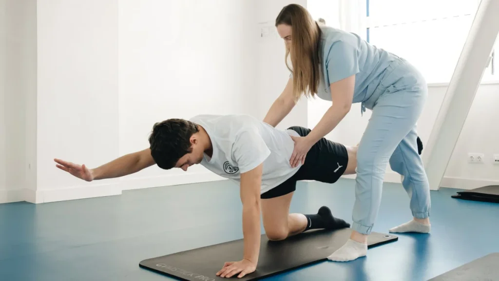 Therapist helping a patient exercise, one factor that affects herniated disc healing