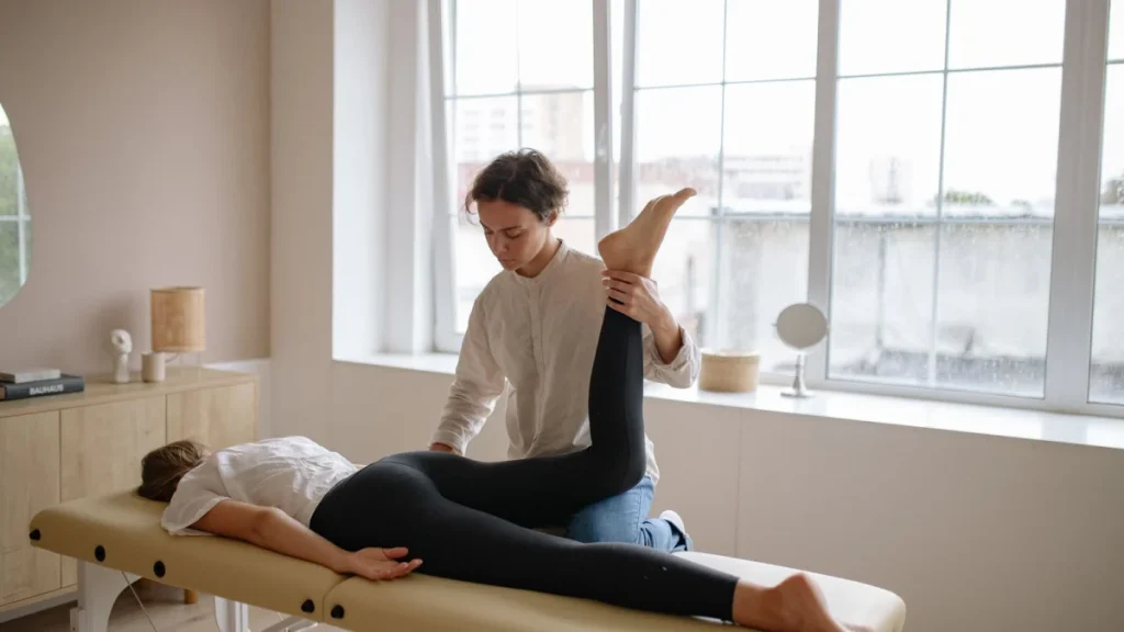 Therapist lifting a woman's leg in a stretch used to treat sciatica