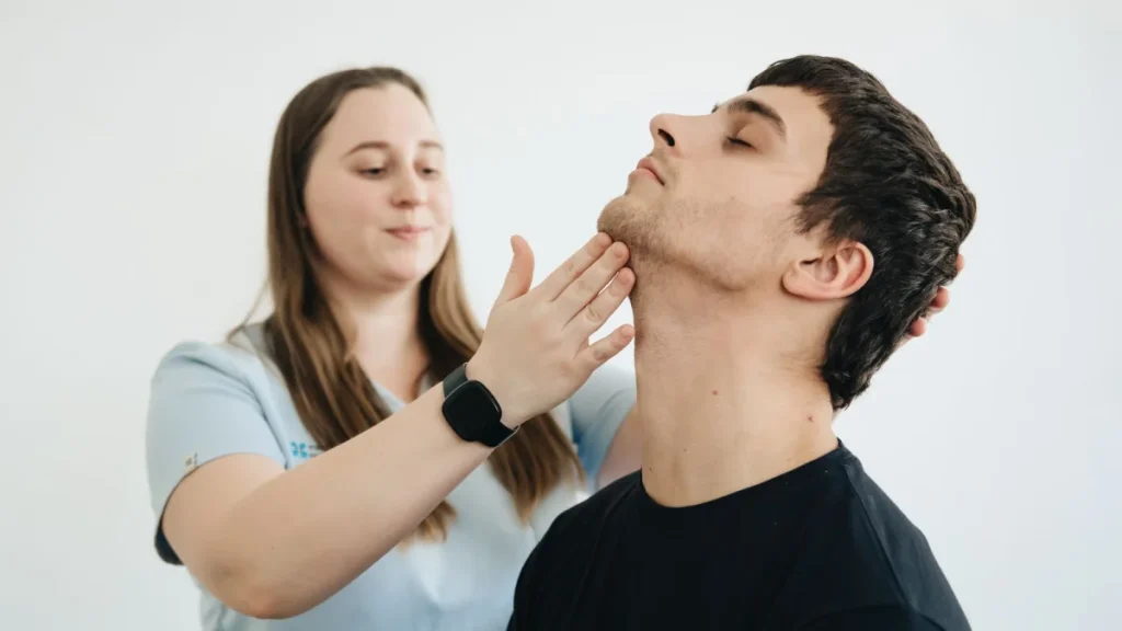 Therapist guiding neck exercises for whiplash rehabilitation after a car accident