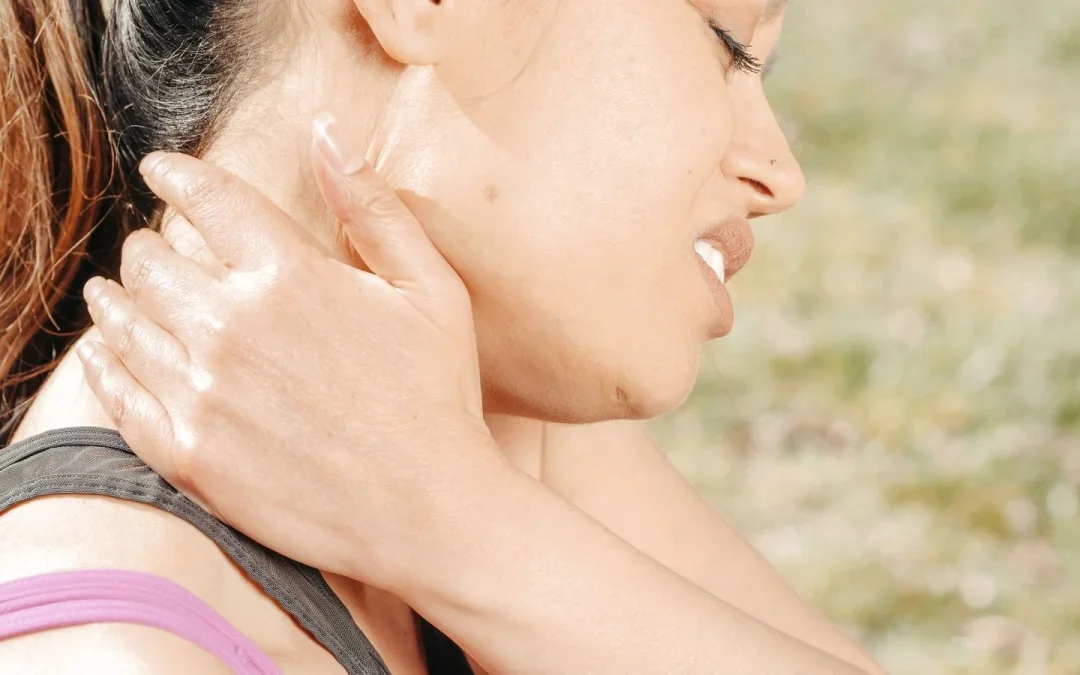 Woman holding her sore neck, a common whiplash symptom after a car crash