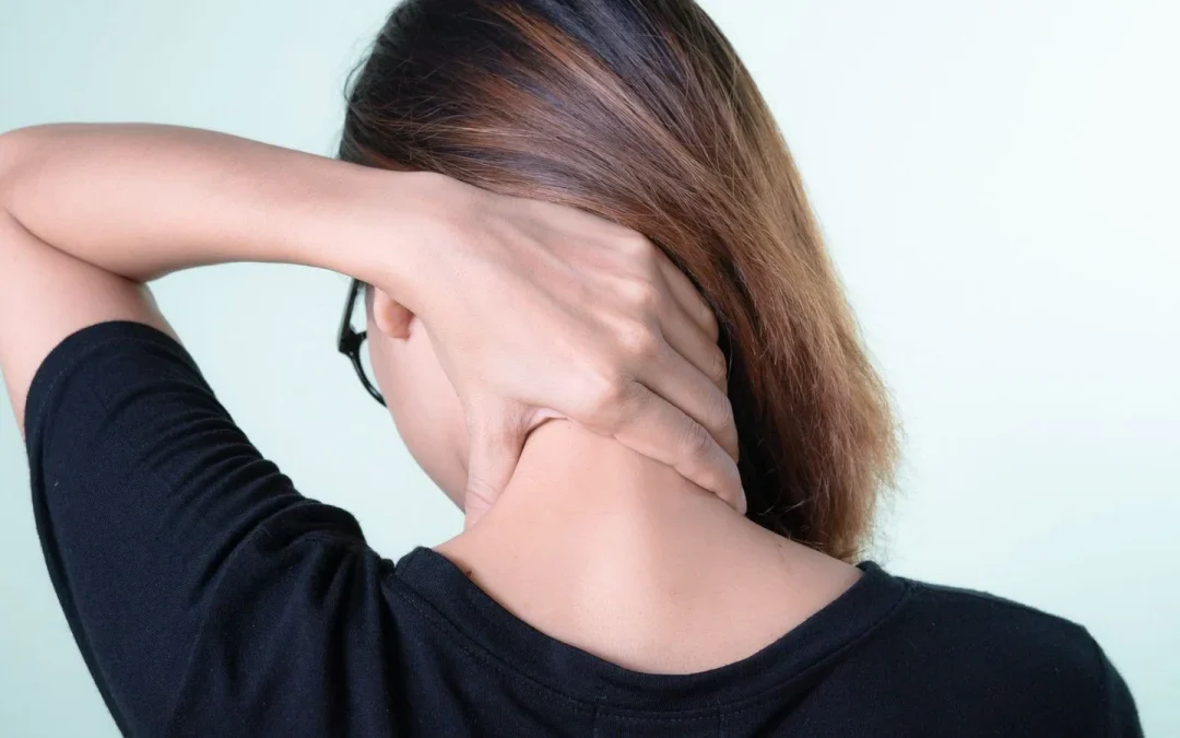 Woman rubbing the back of her stiff neck while looking for quick relief