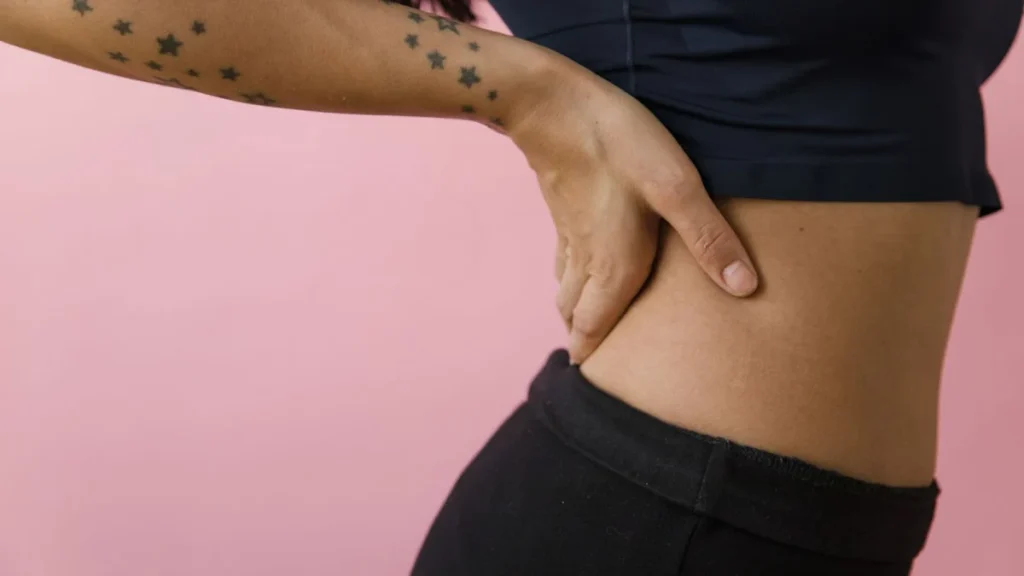 Woman touching her lower back, one of the signs of a herniated disc
