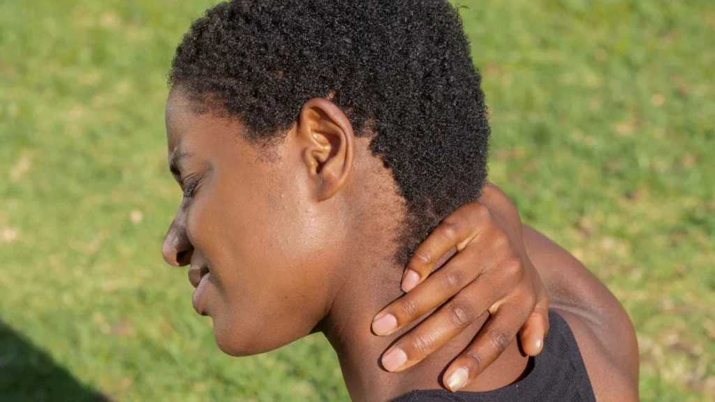 Woman holding her sore neck, one top reason people seek chiropractic care